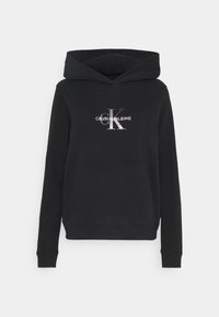 Felpa nera realizzata in morbido tessuto, con tasca frontale e cappuccio regolabile con cordino. Il logo Calvin Klein Jeans è impresso in argento.