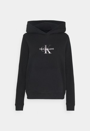 Felpa nera realizzata in morbido tessuto, con tasca frontale e cappuccio regolabile con cordino. Il logo Calvin Klein Jeans è impresso in argento.