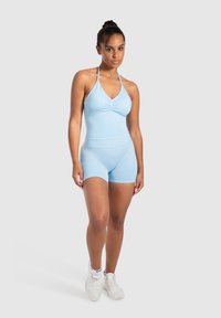 Body sportivo azzurro chiaro con collo all'americana, dettaglio anteriore arricciato e pantaloni corti abbinati. Tessuto morbido con un design aderente.