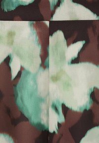 Tela con un patrón floral en tonos verdes, aqua y marrones. Textura suave con formas abstractas, que presenta colores mezclados y sutiles contrastes.