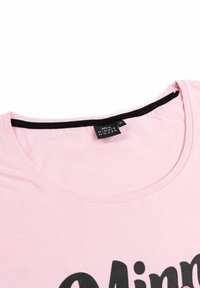 Collo di una maglietta rosa con cucitura interna nera e etichetta del brand Disney Minnie Mouse di taglia M attaccata al colletto.