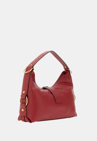 Borsa a spalla in pelle rossa con finitura texturizzata, forma curvata e dettagli in metallo dorato. Dotata di un'unica tracolla e chiusura magnetica.