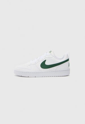 Ténis brancos com um acabamento liso, apresentando um logo Swoosh verde e detalhes, atacadores lisos e uma sola texturizada para tração.