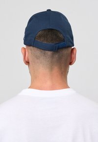Marineblå baseballcaps med buet skygge og justerbar rem bak, laget av lett materiale. Enkelt design, ingen synlige logoer.