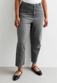 Los jeans de talle alto gris tienen un corte relajado y un diseño de pierna recta. El denim tiene una textura suave y un desvanecimiento sutil.