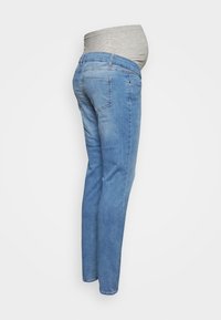 Calças de maternidade em denim azul claro com um painel de barriga em jersey cinza. Design ajustado com bolsos traseiros padrão e bainhas terminadas.