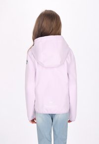 Giacca impermeabile lilla con cappuccio, texture liscia e dettaglio del logo sul maniche. Abbinata a jeans azzurri.