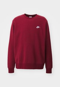 Mörkröd crewneck sweatshirt med långa ärmar och en liten vit Nike-logotyp på vänster bröst.