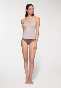 Camisola beige con spalline sottili, texture liscia, abbinata a mutandine viola a vita bassa, con taglio classico e design minimalista.