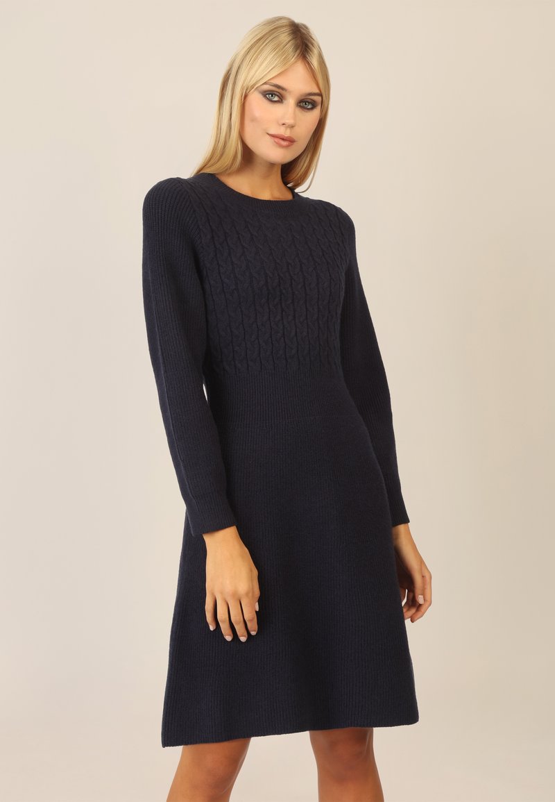 Navy blue dzianinowa sukienka z długimi rękawami, o fakturowanym wzorze w warkocze na torsie i rozkloszowanym dolnym końcu, wykonana z miękkiego, grubego materiału.