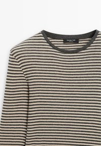 Maglione a maniche lunghe a righe in beige e grigio antracite con scollo a girocollo e etichetta all'interno del colletto.