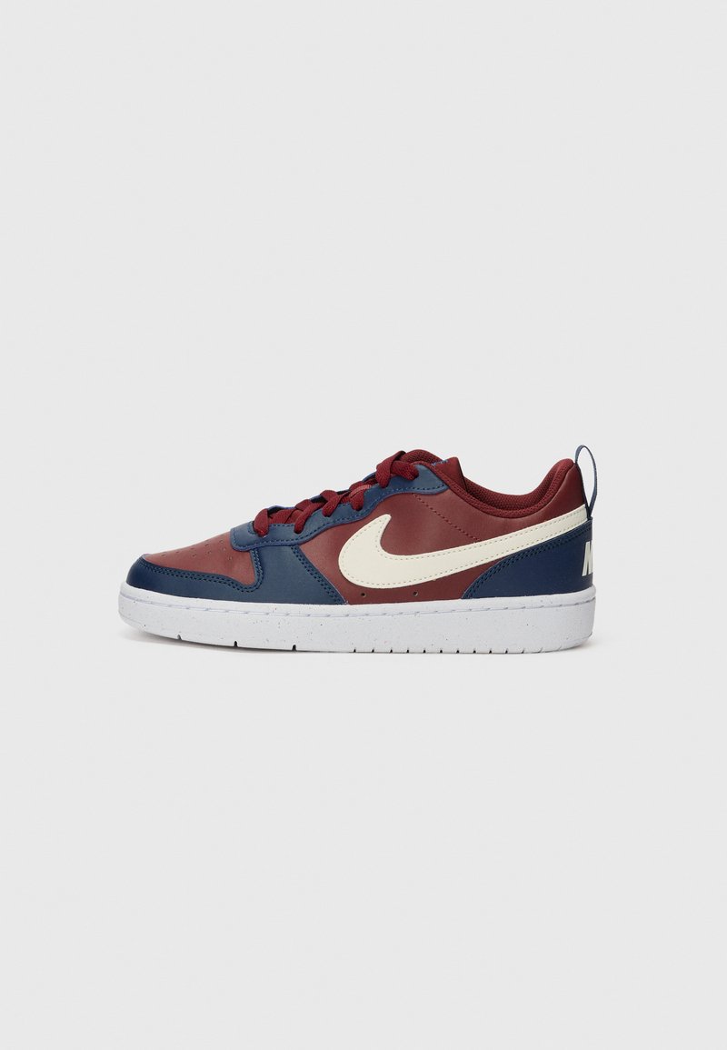 Sapatilha multicolor com parte superior em couro nas cores azul-marinho e bordô, apresentando um logo swoosh branco, atacadores redondos e sola em borracha texturizada.