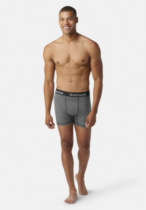 Graue Boxer-Briefs mit einem schwarzen Bund, auf dem "Smartwool" steht. Weicher Stoff mit bequemer Passform, ausgestattet mit einem glatten, nahtlosen Design.