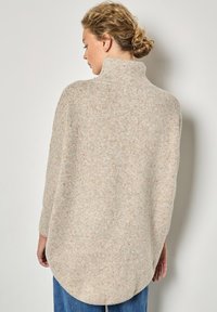 Maglione beige a maglia con colletto alto, orlo arrotondato e finitura testurizzata, caratterizzato da piccole macchie multicolori in tutto il capo. Maniche lunghe.
