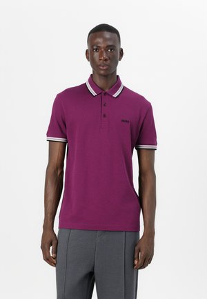 Polo shirt violet avec col et poignets rayés blancs ; présente une patte de boutonnage à trois boutons et un petit logo brodé sur la poitrine.