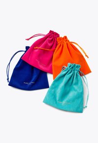 Quattro sacchetti in suede con coulisse di colore blu, rosa, arancione e turchese, ognuno dei quali presenta un logo dorato "Kurt Geiger London" stampato sul davanti.