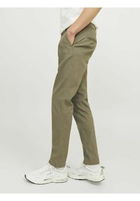 Khaki-broeken van katoen met een slim fit en zijzakken. Draag met witte sneakers met een minimaal ontwerp en lichte accenten.