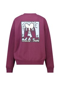 Sweatshirt bordeaux avec un design graphique représentant deux mains tenant un cœur, situé dans un contours rectangulaire au dos. Matière douce.