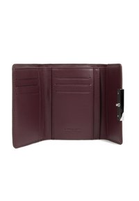 Portafoglio in pelle bordeaux con più scomparti per carte, chiusura in metallo argentato e texture morbida. Nome del marchio impresso all'interno.