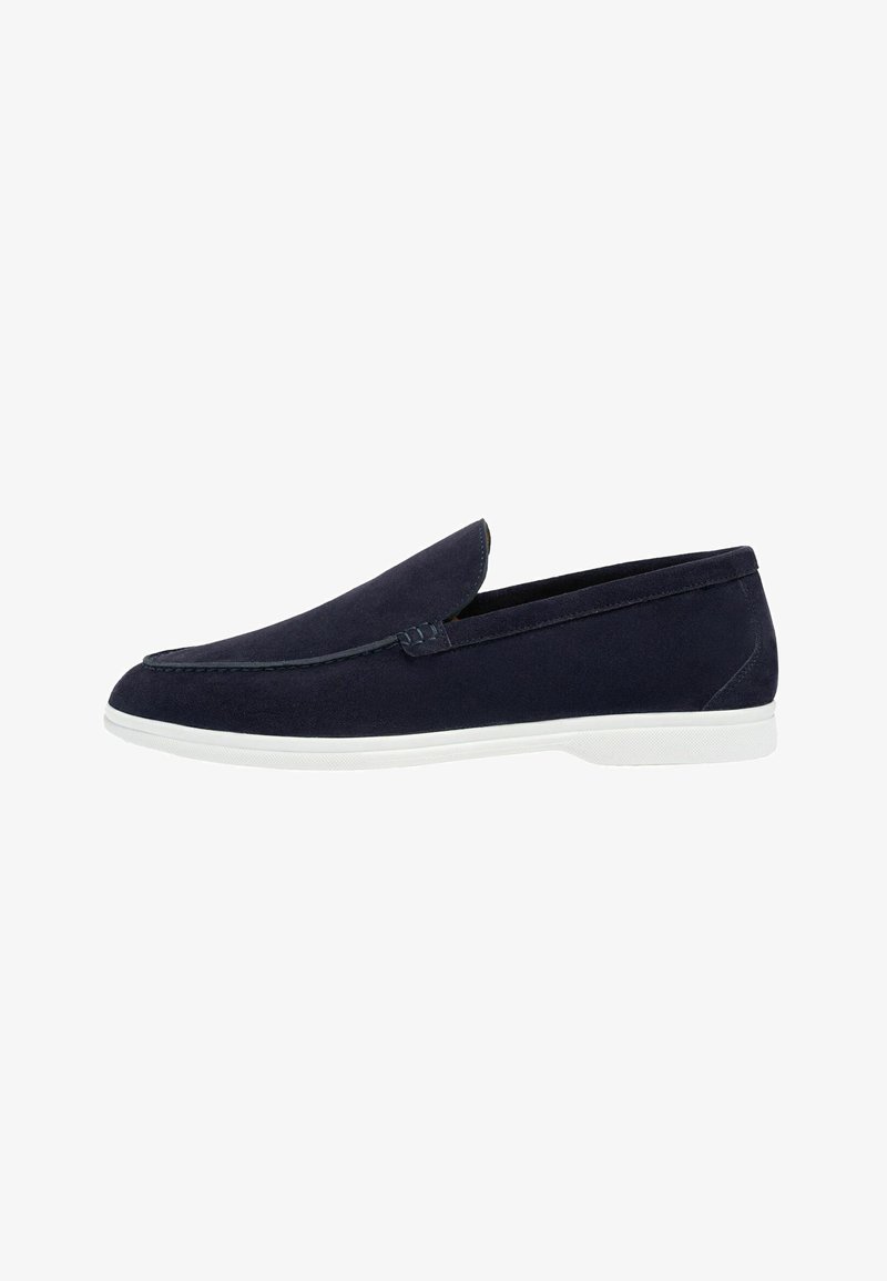 Mocassin en daim bleu marine avec semelle en caoutchouc blanche, design sans lacets et couture minimale le long du bord supérieur.