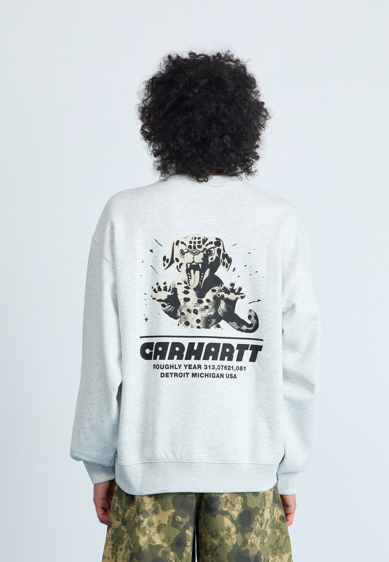 Grå sweatshirt med ett grafiskt motiv av en fläckig hund i svart, texten "Carhartt" och ribbade manschetter. Bärs med kamouflage-shorts.