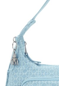 Ljusbl å tygväska med texturerade mönster, dragkedjestängning och en subtil silverfärgad nyckelring med en liten figur.