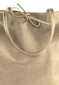 Leren schoudertas in een gestructureerd metallic grijs. Voorzien van twee ronde handvatten en een knoopsluiting aan de bovenkant. Gladde afwerking en een zachte uitstraling.