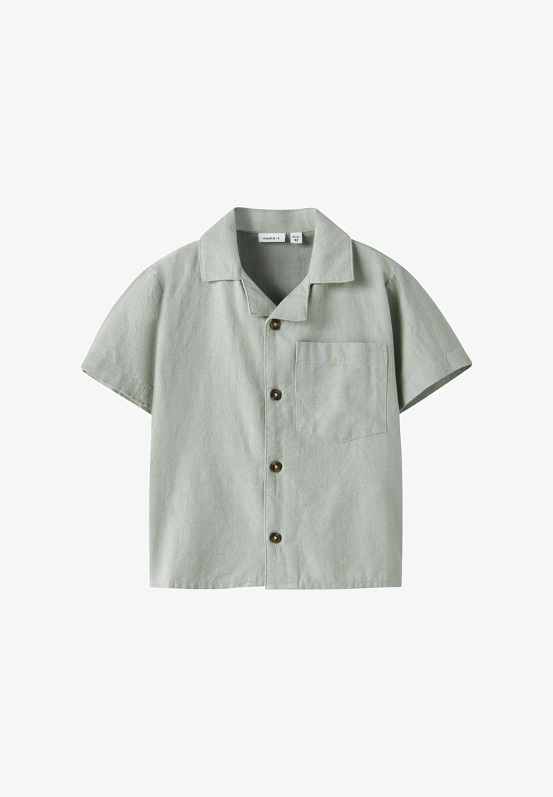 Rövid ujjú, zöld ing, texturált anyagból készült, galléros, gombos záródással, bal oldalon négyzet alakú mellzsebbel.