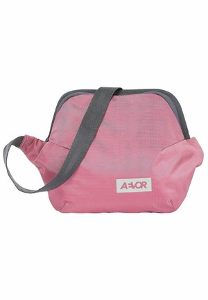Small pink shoulder bag with gray strap, gray trim, and white label with red text on front.