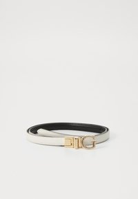Witte riem met een gouden gesp, versierd met decoratieve rhinestones, tegen een effen witte achtergrond. De riem heeft een zwarte binnenkant.