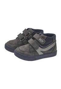 Zapatos de gamuza gris oscuro para toddlers con acentos de malla azul marino, dos correas de velcro y un elemento de diseño en un gris claro contrastante. Texto "NIÑO" en la correa.