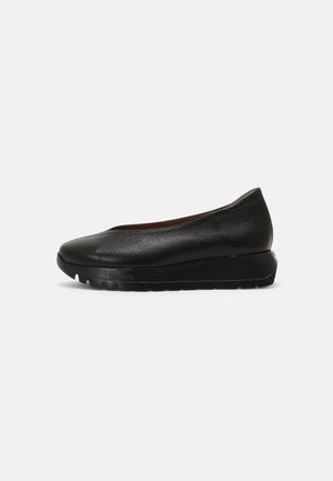 Chaussure en cuir noire à enfiler avec bout rond et semelle épaisse et rembourrée, adaptée pour un usage décontracté ou formel.