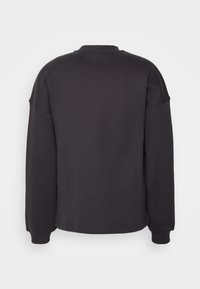 Felpa grigio scuro con scollo rotondo, spalle scese e polsini a coste. Tessuto liscio, senza motivi visibili o elementi decorativi.