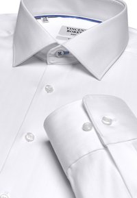 White dress shirt with herringbone texture, pointed collar, and blue-accented inner neck. Features clear buttons and single-button cuff.
