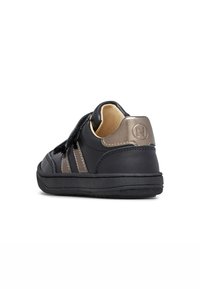 Sneaker in pelle nera con una finitura testurizzata, dettagli grigi e una fascia in velcro. Presenta una punta rotonda e una suola in gomma per una buona aderenza.