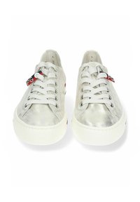 Srebrne sneakersy z metalicznym wykończeniem, białe gumowe podeszwy i płaskie sznurówki. Na sznurówkach znajduje się czerwona i czarna metka.