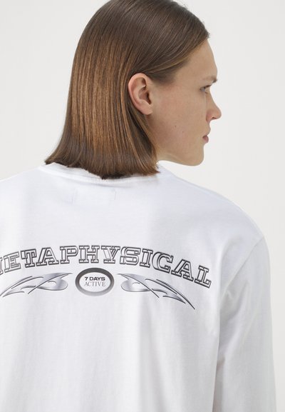 White cotton long sleeve t-shirt featuring a large black print text "METAPHYSICAL" on the back, with “7 DAYS ACTIVE” in a circular design below it.