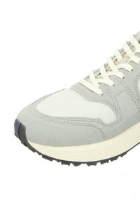 Grey sneaker featuring a combination of suede and mesh materials, with a textured sole and contrasting white accents on the upper.