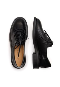 Scarpe in pelle nera con finitura liscia, punta arrotondata, design con lacci e un tacco nero robusto. Internamente presentano una fodera beige.