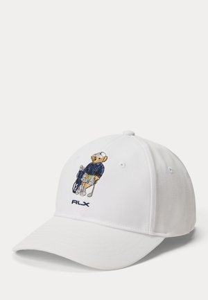 Hvid baseballkasket med broderet bjørn iført golfbeklædning og med golfkøller, "RLX"-logo under bjørnen.