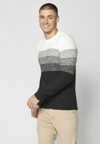 Pulover tricotat cu un model gradient în nuanțe de alb, gri și negru. Mansete și tiv cu nervuri, țesătură texturată pe tot parcursul.