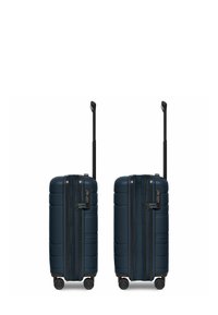 Marineblauwe hardshell koffer met gestructureerd oppervlak, dubbele ritsen, combinatie slot, uitschuifbare zwarte handgreep en vier draaiwielen.