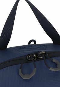 Marineblauwe stoffen tas met een gestructureerde oppervlakte, voorzien van dubbele rits-trekker tabs, stevige handvatten en een versterkt stikselontwerp.