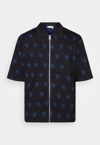 Camicetta nera a maniche corte con motivi a forma di cuore blu e verde. Presenta un colletto e una zip frontale. Realizzata in tessuto morbido con una superficie liscia.