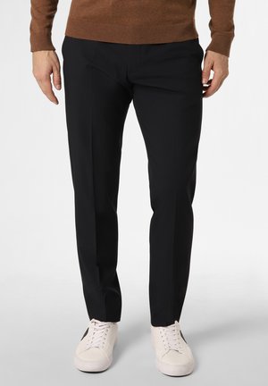 Schwarze Slim-Fit-Hosen aus einem glatten Stoff, mit flachem Bund, seitlichen Taschen und taillierter Passform. Getragen mit weißen Sneakers.