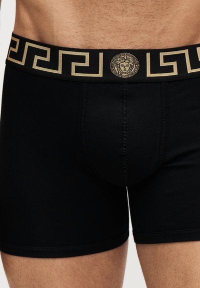 Boxer noir pour homme avec une ceinture noire et dorée à motif clé grecque et un logo central représentant une tête de Méduse.