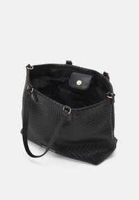 Black woven leather tote bag with a spacious interior, featuring gold-toned hardware and a top snap closure. Lined with black fabric.