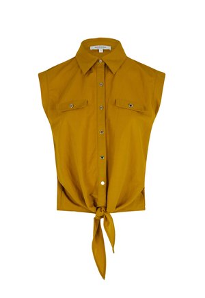 Mosterdgele mouwloze shirt met kraag, voorzien van knoopsluiting, twee klepzakken en een geknoopt detail aan de voorkant.