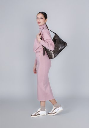 Maglione rosa chiaro e gonna coordinata con un design aderente, abbinati a sneakers bianche e una borsa tote marrone scuro. Texture liscia in tutto.