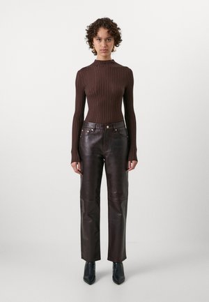 Brown ribbed long-sleeve sweater paired with dark brown leather pants. The pants feature a straight fit and gold hardware accents. Black pointed shoes.